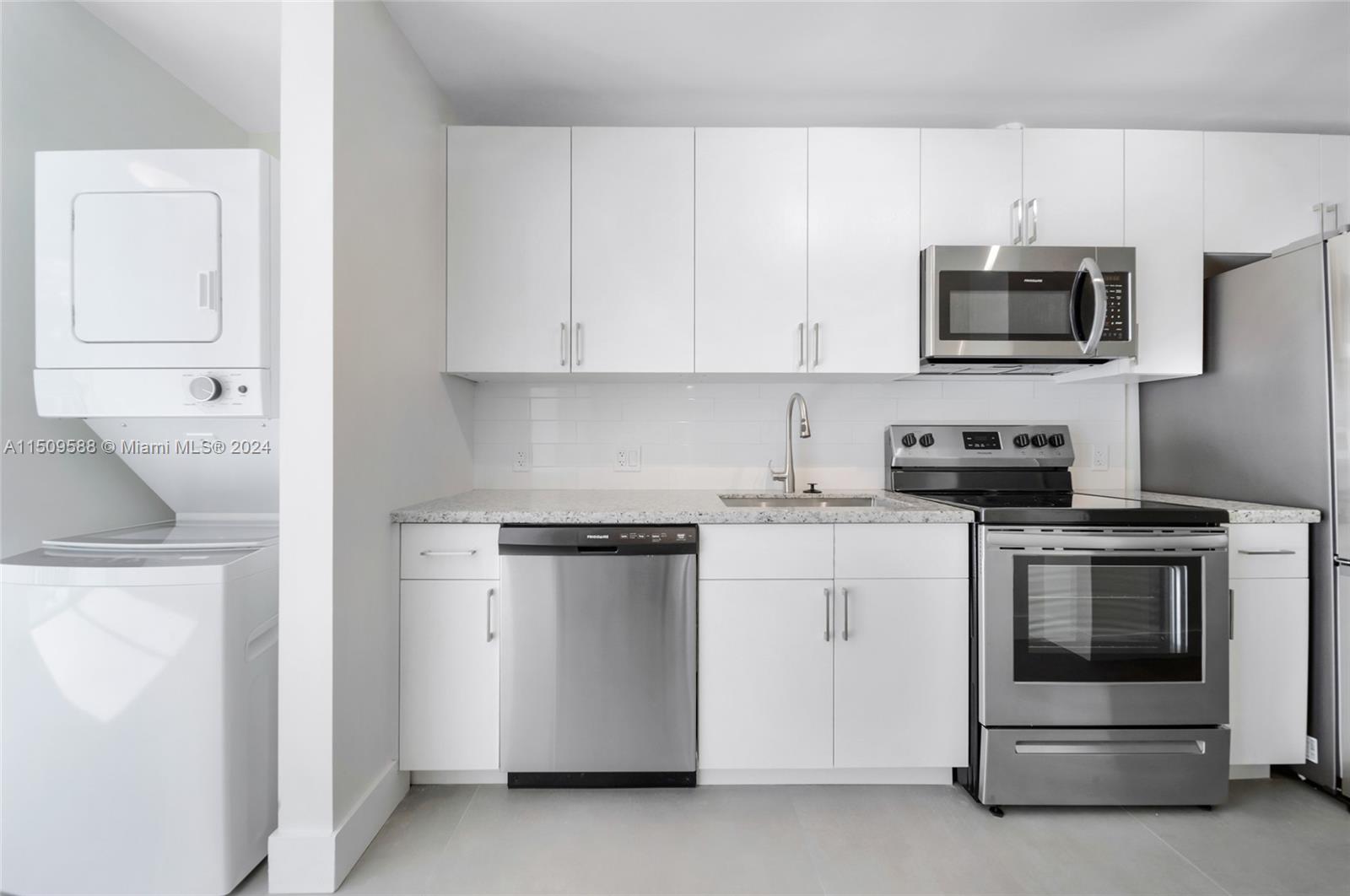 a kitchen with stainless steel appliances granite countertop white cabinets and a stove