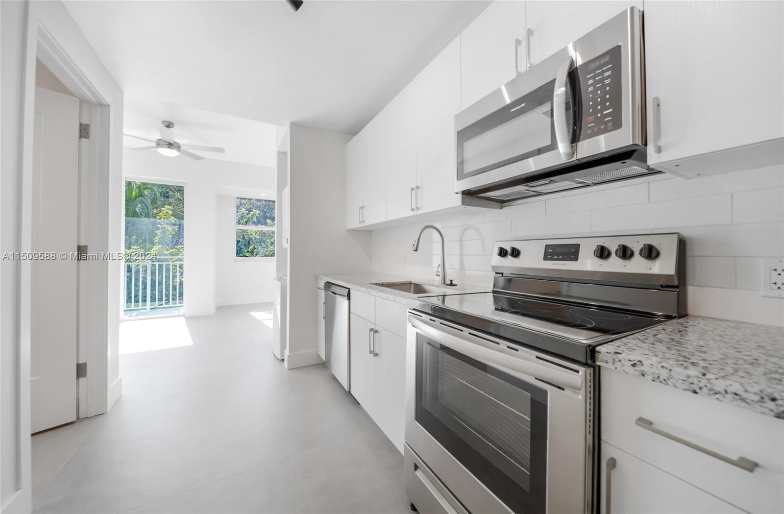 Civic Center Miami, FL 33125 - Photo 9 of 19 a kitchen with stainless steel appliances granite countertop a stove and a microwave