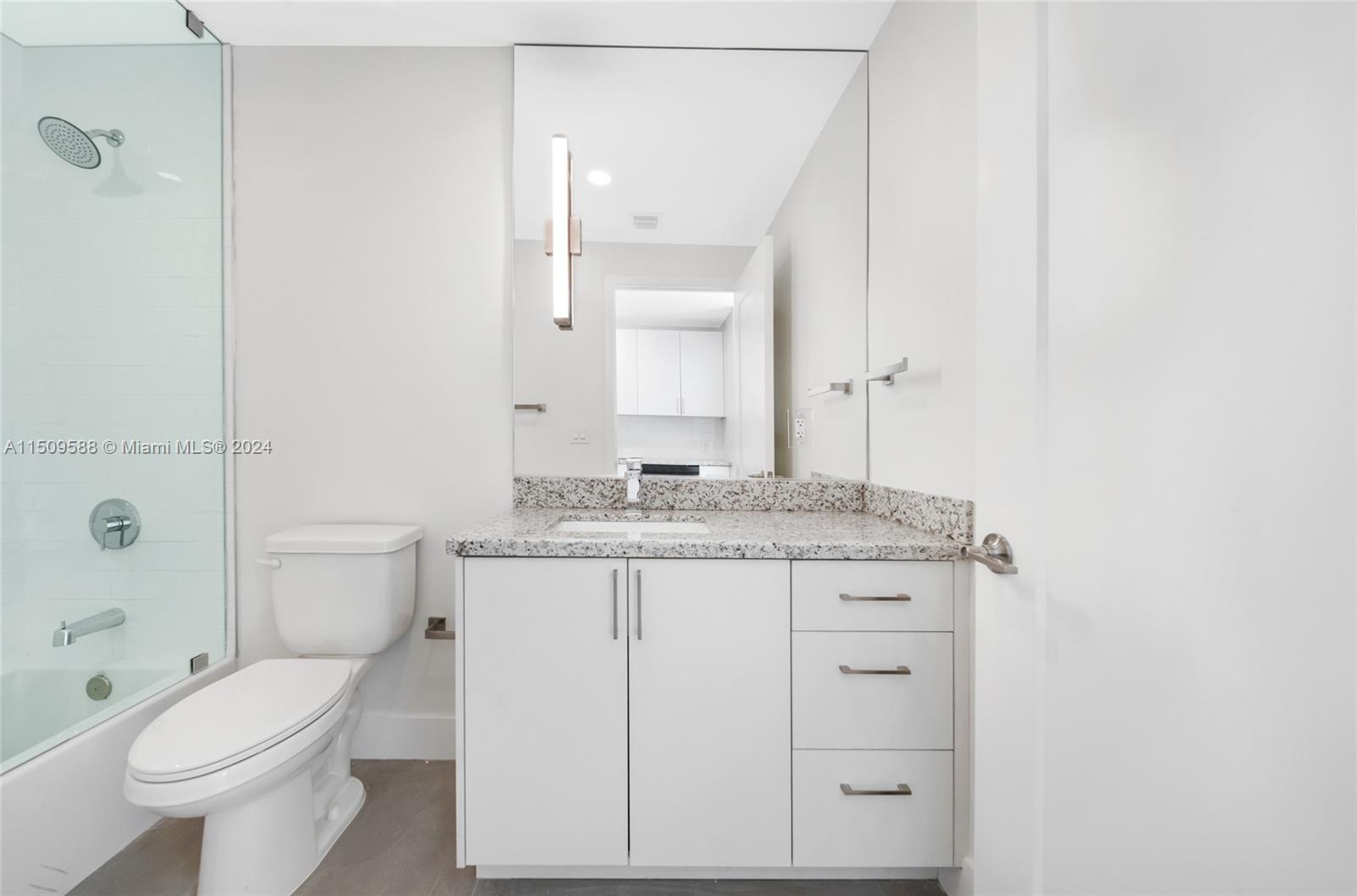 Civic Center Miami, FL 33125 - Photo 10 of 19 a bathroom with a granite countertop toilet a sink and a mirror