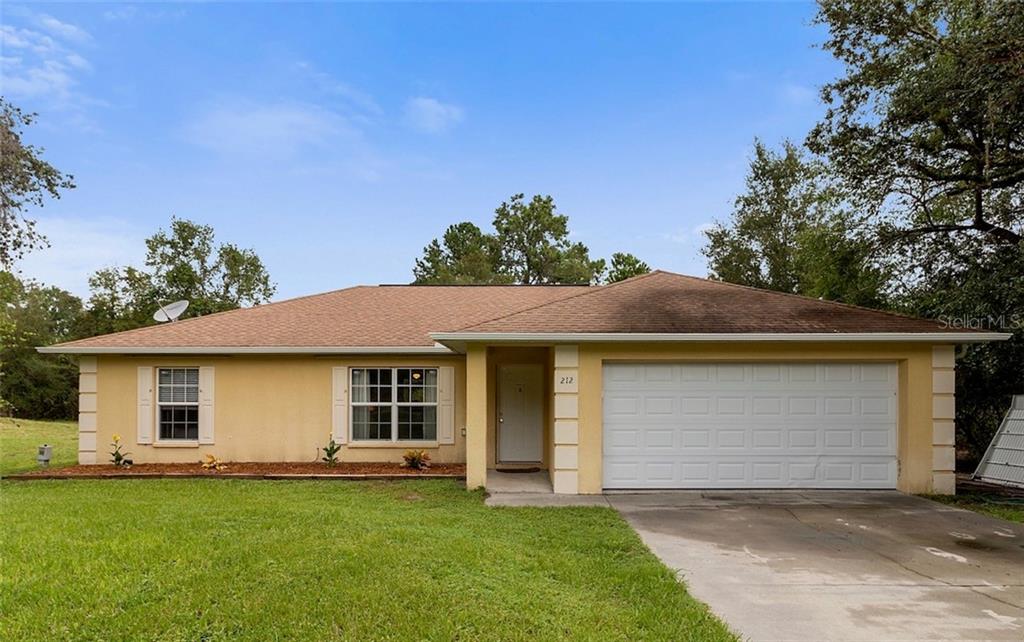 212 Oak Ln Road Ocala, FL 34472 - Photo 1 of 1 a front view of a house with a garden