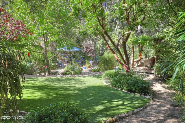 a view of a patio with table and chairs under an umbrella