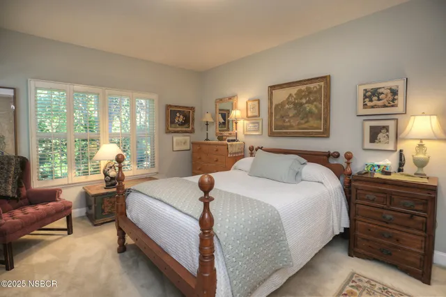 a spacious bedroom with a bed and wooden floor