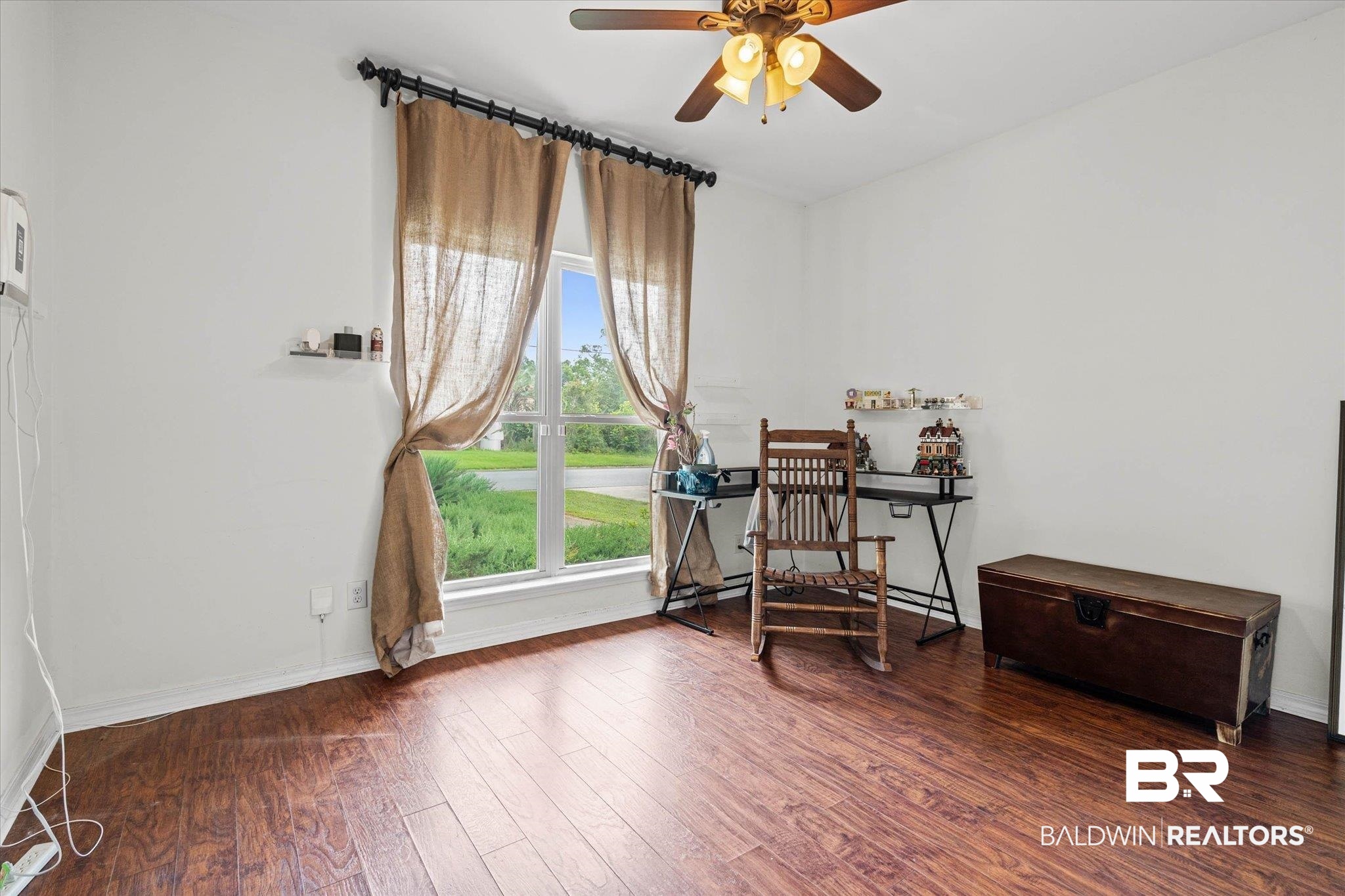 800 Galoway Avenue Mobile, AL 36609 - Photo 17 of 22 Room featuring wood-finish flooring, a large window, a ceiling fan with integrated lighting, and white baseboards