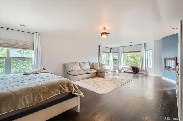 a spacious bedroom with a bed and wooden floor
