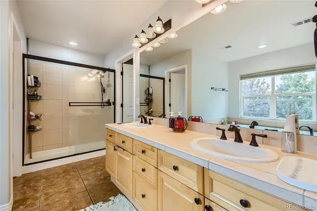 a bathroom with a double vanity sink mirror and shower