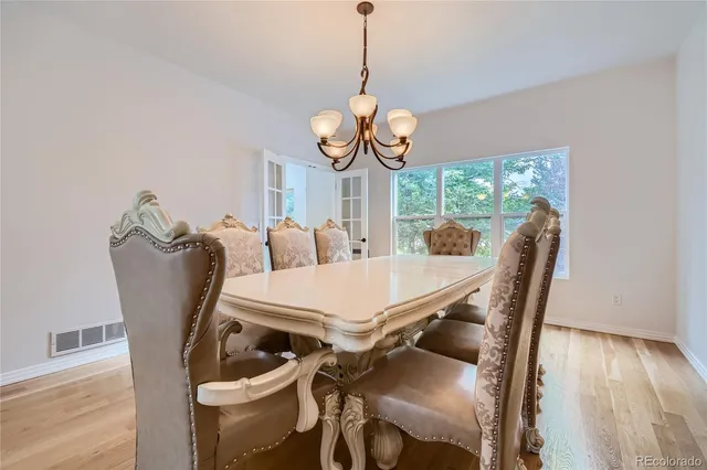 a view of a dining room with furniture wooden floor and chandelier