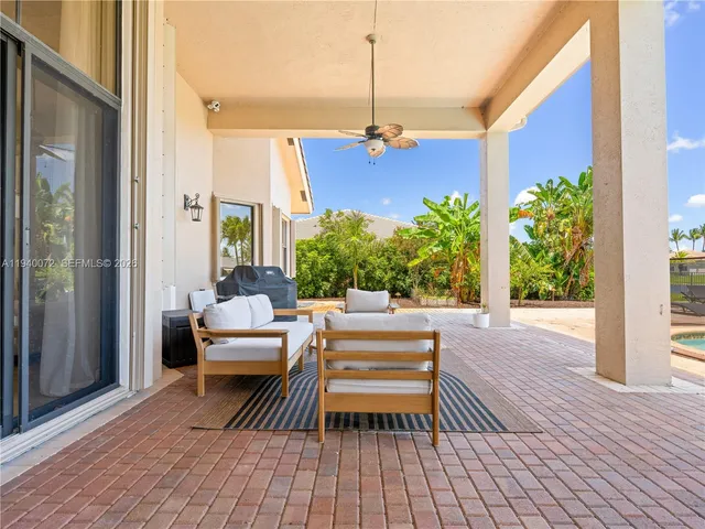 a view of backyard with table and chairs under an umbrella