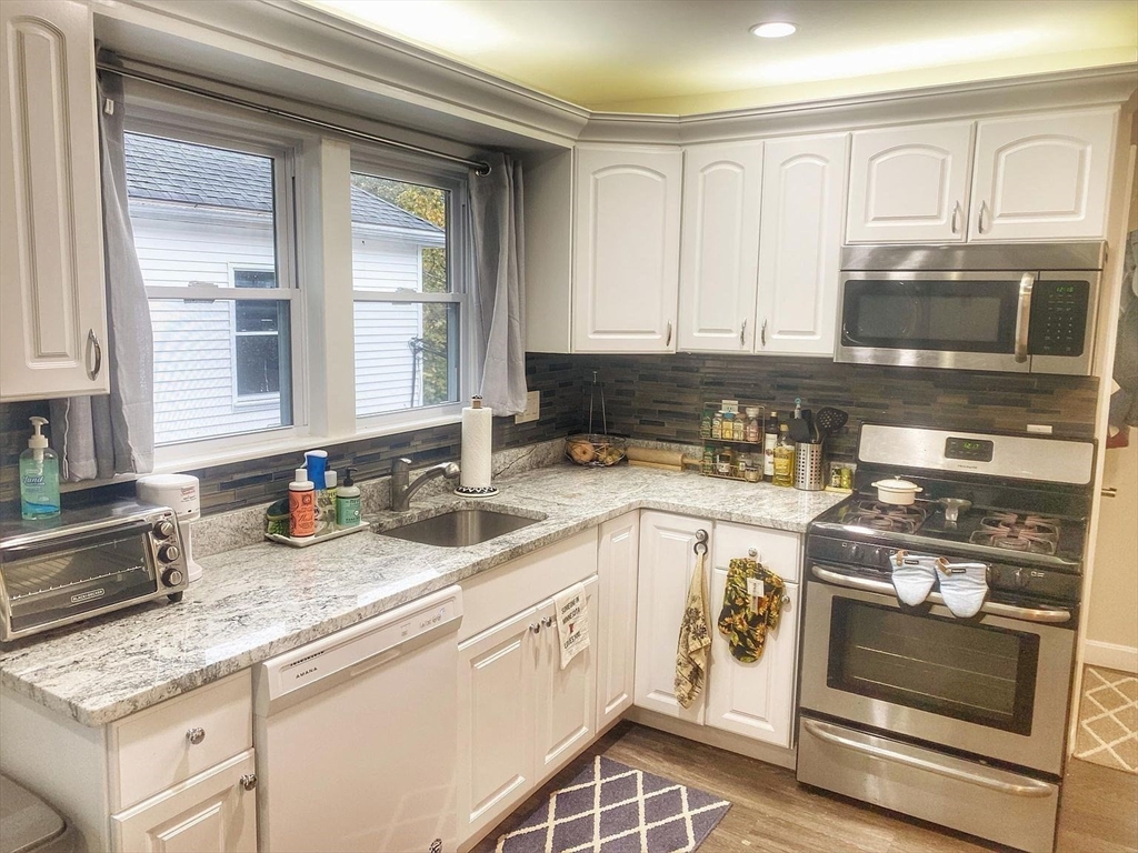 28 Francis Street, Unit 2 Waltham, MA 02451 - Photo 2 of 11 a kitchen with stainless steel appliances granite countertop a stove a sink and a microwave