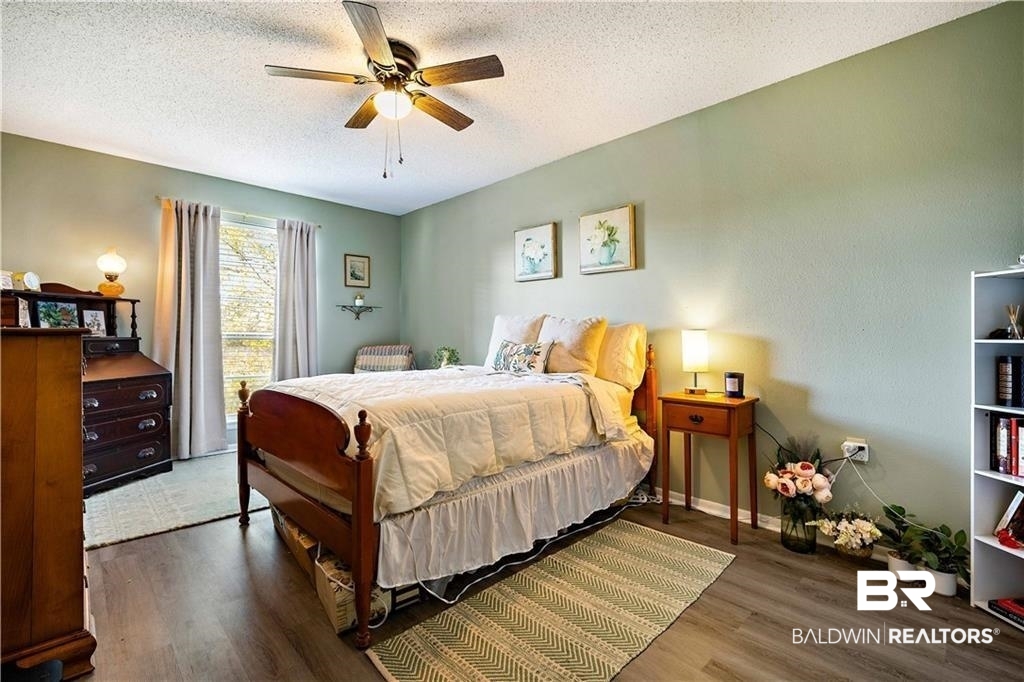 239 Riverbend Drive, Unit 239 Mobile, AL 36605 - Photo 12 of 26 Bedroom with ceiling fan, a textured ceiling, and dark hardwood / wood-style floors