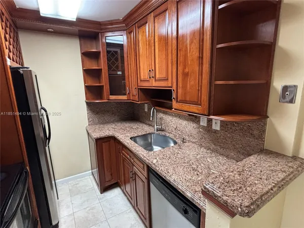 a kitchen with a sink a refrigerator and wooden floor