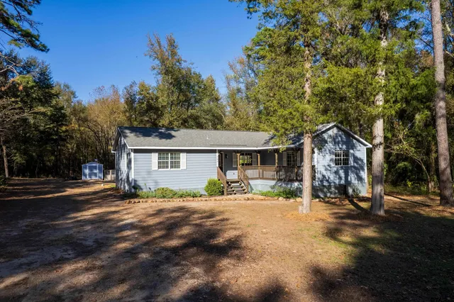 a backyard of a house with barbeque oven and outdoor seating