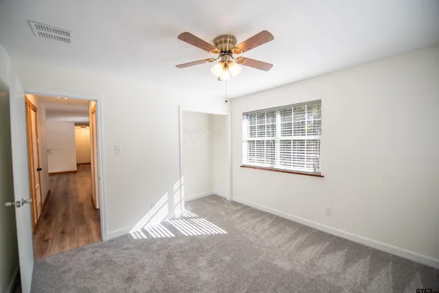 a view of a livingroom with a ceiling fan and window