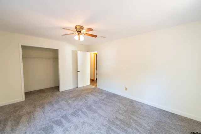 a view of a room with a ceiling fan and a window