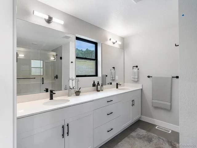 a bathroom with a double vanity sink mirror and
