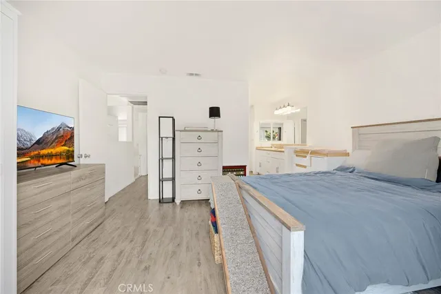 a bed room with a bed and a view of kitchen