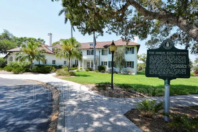 a view of a park that has a sign board large trees