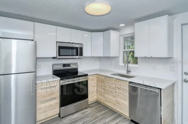 a kitchen with a sink stainless steel appliances and white cabinets