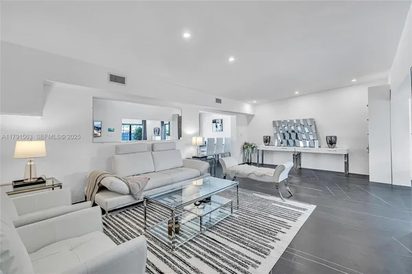 a living room with furniture and view of kitchen