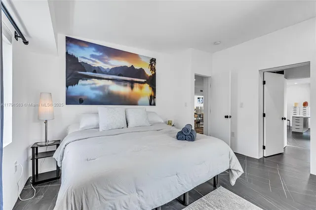 a bedroom with a bed and a painting on the wall