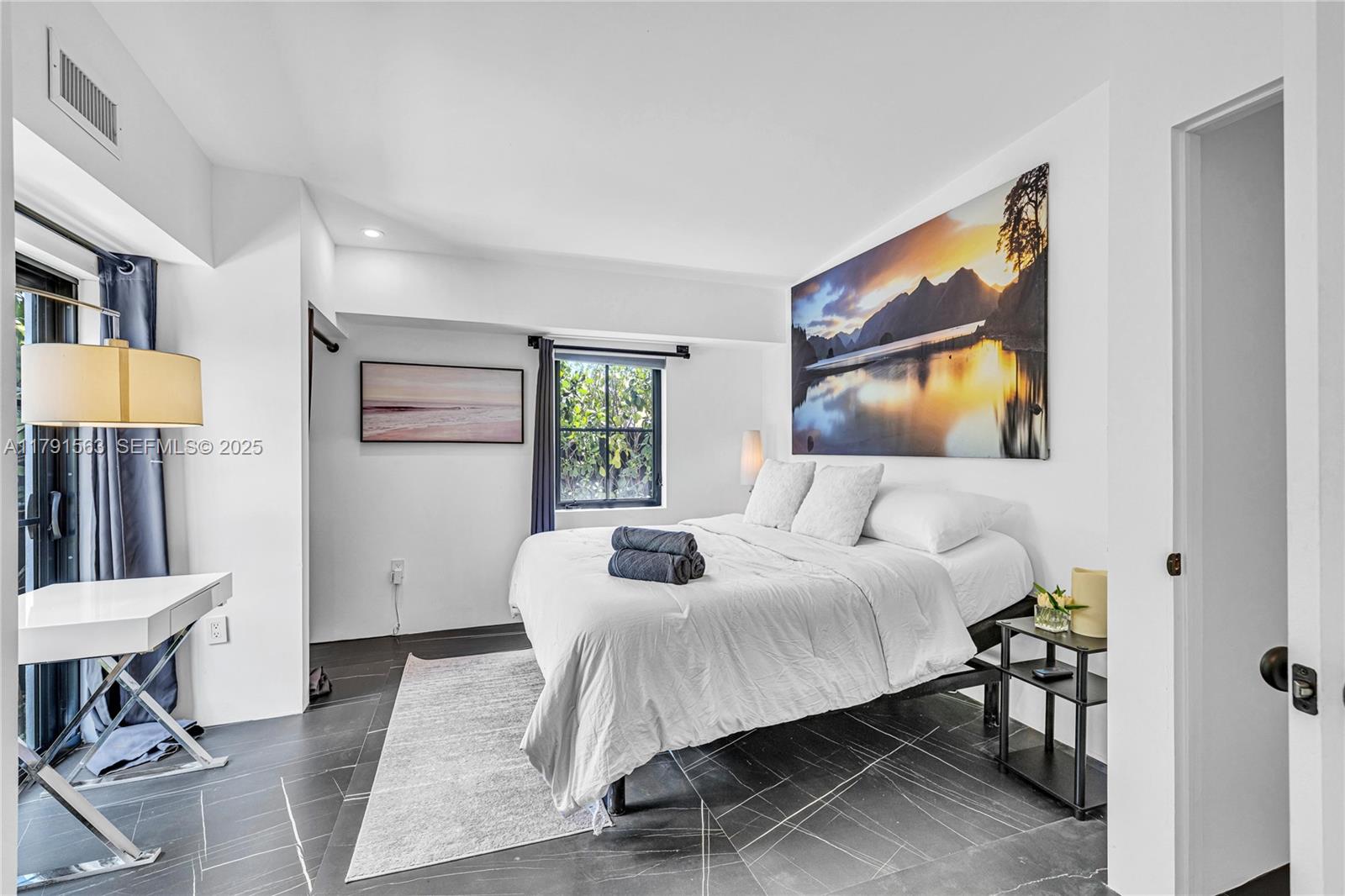 560 Northwest 116th Terrace Miami, FL 33168 - Photo 19 of 50 a bedroom with a bed a mirror and a table in it