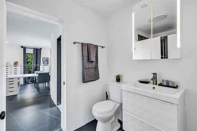a bathroom with a toilet sink and mirror