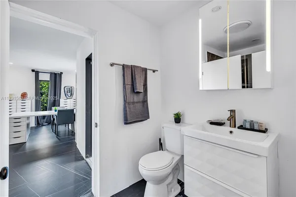 a bathroom with a toilet sink and mirror