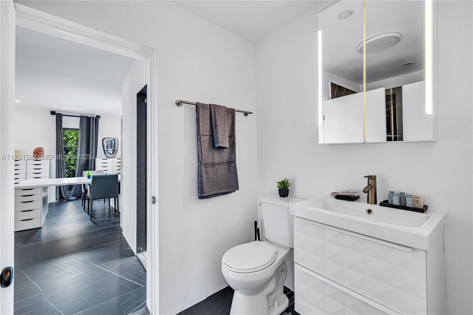 560 Northwest 116th Terrace Miami, FL 33168 - Photo 21 of 50 a bathroom with a toilet sink and mirror