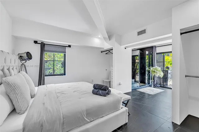 a bedroom with a bed and a large window