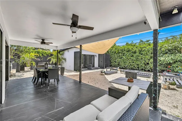 a living room with patio furniture and a large window