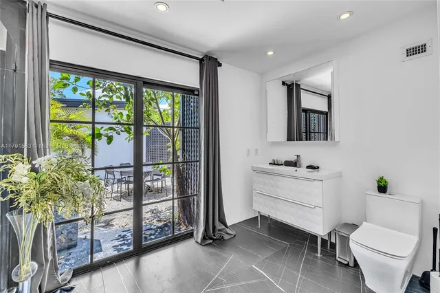 a bathroom with a toilet a sink and a large mirror