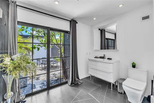 a bathroom with a toilet a sink and a large mirror