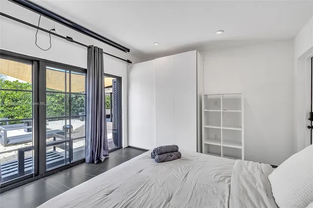 a bedroom with a large bed and wooden floor