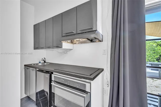 a view of a kitchen with sink and cabinets