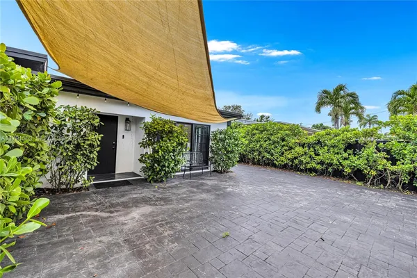 a view of a house with plants and a yard