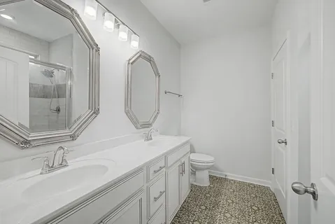 a bathroom with a granite countertop sink a toilet and a mirror