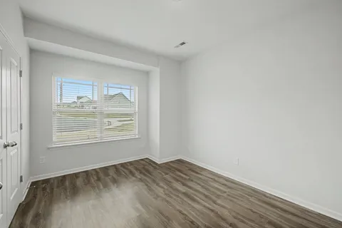 an empty room with wooden floor and a window