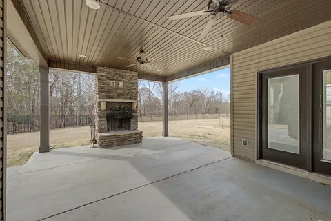 a view of an empty room with a fireplace and a window