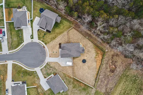 an aerial view of a house with a yard and trees