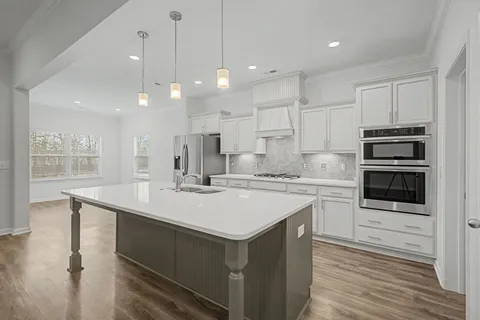 a kitchen with kitchen island a sink stainless steel appliances and cabinets