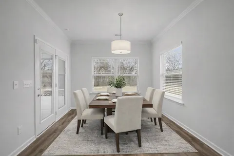 a dining room with furniture a chandelier and wooden floor