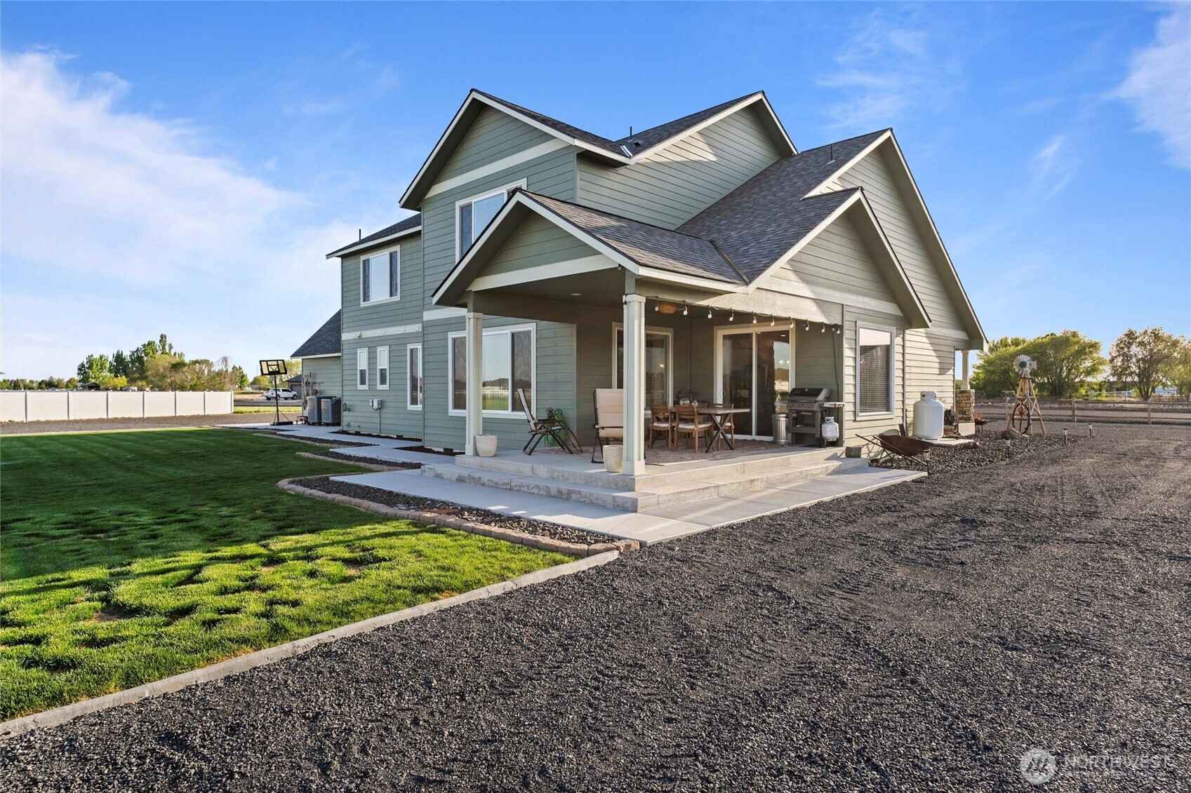 5889 Ne Road Moses Lake, WA 98837 - Photo 7 of 39 a view of a white house with a big yard and potted plants