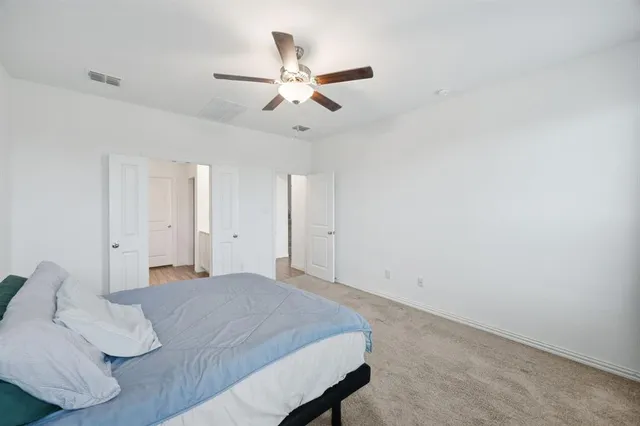 a bed room with a bed and a ceiling fan