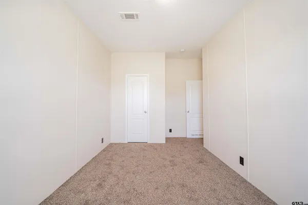 an empty room with a ceiling fan and a window