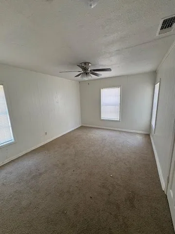 a view of a livingroom with a ceiling fan and window