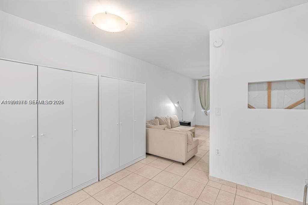 200 76th Street, Unit 59 Miami Beach, FL 33141 - Photo 9 of 16 a room with a bed and a lamp on a dresser