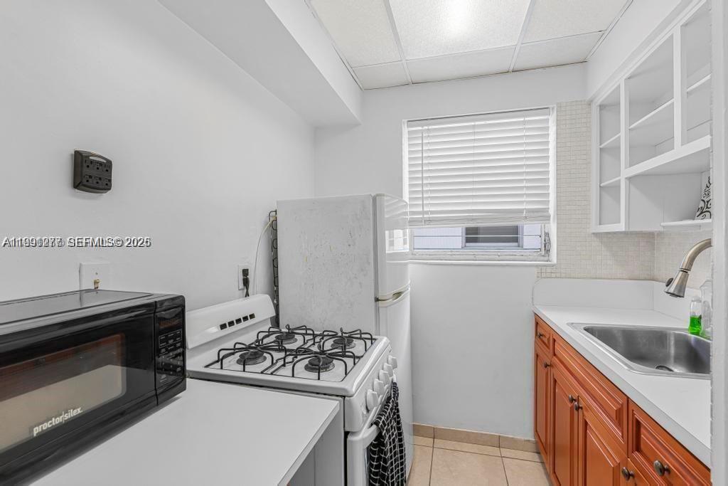 200 76th Street, Unit 59 Miami Beach, FL 33141 - Photo 10 of 16 a kitchen that has a sink and a stove