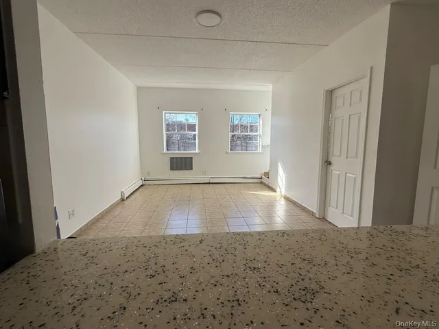 an empty room with wooden floor and window