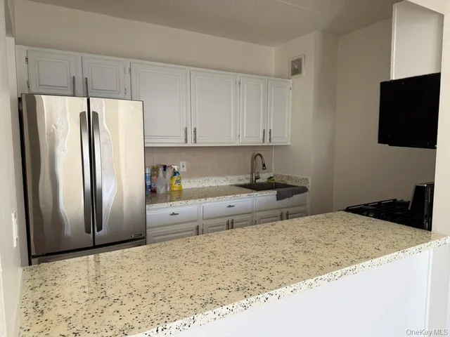 a kitchen with stainless steel appliances granite countertop a refrigerator sink and cabinets