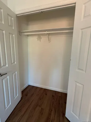a view of walk in closet with wooden floor
