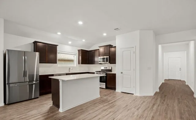 a kitchen with stainless steel appliances a refrigerator stove and microwave